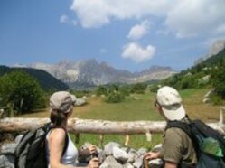 Zwei Wanderer schauen von einem Berg auf die Landschaft Albaniens und Griechenlands