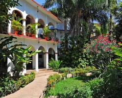 Ein weißes Gebäude in Chiapa de Corzo, welches voll mit tropischen Pflanzen ist