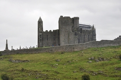 Die Burg von Rock of Cashel umgeben von grüner Wiese 
