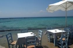 Zwei Restauranttische am Meer auf Kreta