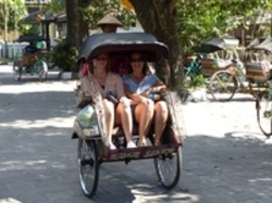 Zwei Leute auf einem Becak bzw einem Fahrradtaxi